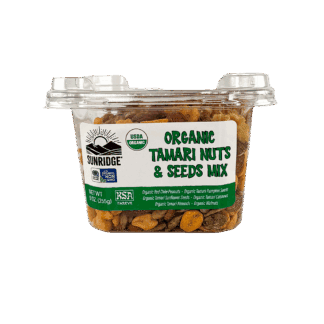 A plastic tub of Organic Tamari Nuts & Seeds Mix - 12 Count, 9 oz. Tub filled with a mix of tamari-coated nuts and seeds.